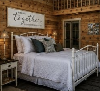 Cottage bedroom with an iron bed, warm wood walls and soft lamplight