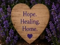 A wooden heart sign reading "Hope. Healing. Home."