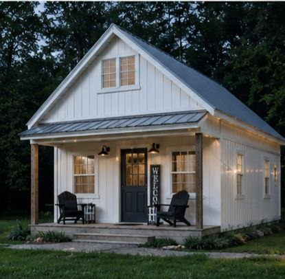 White Amish-built cottage with a covered porch at dusk