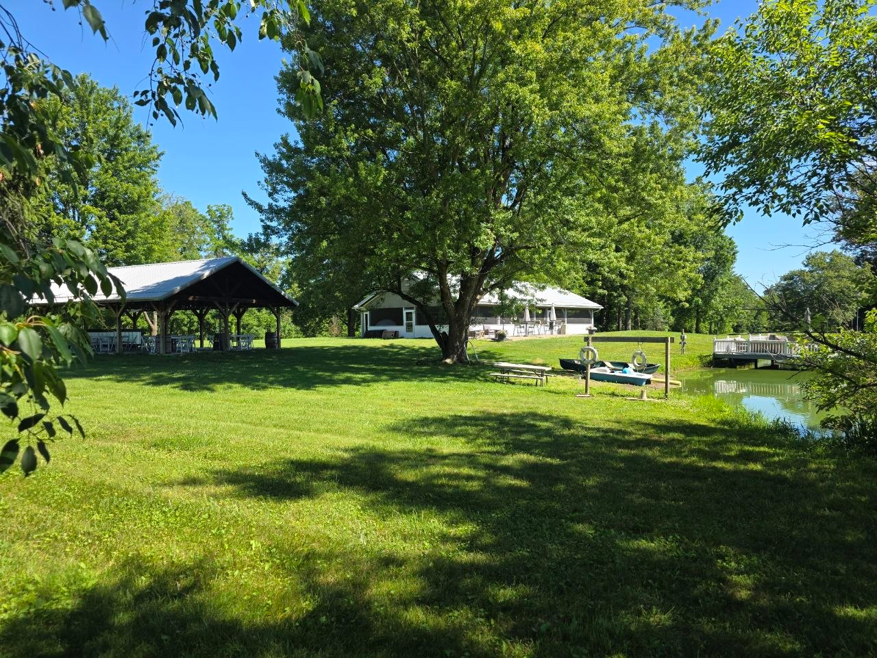 Green lawn sloping to the lake with the pavilion and dock beyond