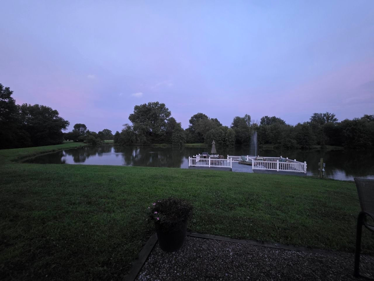 The lake and fountain at blue hour with the far fence line glowing