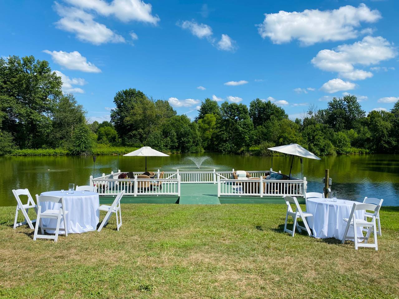 Reception tables on the lawn overlooking the floating dock and fountain