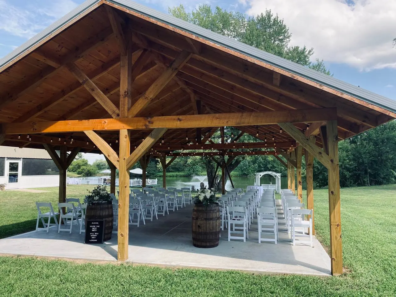 Ceremony seating arranged under the pavilion facing the lake fountain