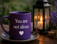 A purple mug reading "You are not alone." beside a lantern